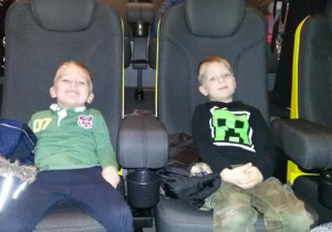 Widok na dwóch chłopców siedzących na widowni kinowej.